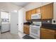 Bright kitchen featuring a stove, microwave, cabinets, and tile backsplash at 3121 Fontana Colony Ct, North Las Vegas, NV 89031