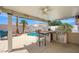 Backyard covered patio with seating and a pool view at 3121 Fontana Colony Ct, North Las Vegas, NV 89031