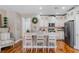 Bright kitchen features white cabinets, stainless appliances, island with breakfast bar and wood floors at 3185 Mura Del Prato Ave, Henderson, NV 89044
