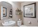 Cozy powder room featuring decorative floral prints, a pedestal sink, and classic fixtures at 3185 Mura Del Prato Ave, Henderson, NV 89044