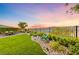 Beautiful backyard with manicured lawn, desert landscape, mountain view, and outdoor seating area at 35 Via Rizzuto, Henderson, NV 89011