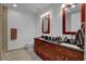 A well-lit bathroom offering double sinks, wood cabinets, framed mirrors, and tile flooring at 4525 Dean Martin Dr # 2109, Las Vegas, NV 89103