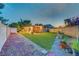 Expansive backyard featuring a covered patio, well-maintained synthetic grass, and colorful landscaping, perfect for outdoor enjoyment at 4556 Kenilworth Ct, Las Vegas, NV 89147