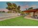 Landscaped backyard with artificial turf, storage shed, and covered patio at 4556 Kenilworth Ct, Las Vegas, NV 89147