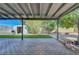 Backyard view featuring a covered patio, artificial turf, storage shed, and mature trees at 4556 Kenilworth Ct, Las Vegas, NV 89147