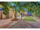 Secluded backyard patio with lush tree providing ample shade, accented by brick pavers and artificial turf at 4556 Kenilworth Ct, Las Vegas, NV 89147