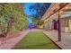 A cozy backyard featuring a charming pergola with string lights, artificial turf, and brick pavers, ideal for relaxation at 4556 Kenilworth Ct, Las Vegas, NV 89147