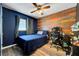 Cozy bedroom with wood accent wall, blue paint, ceiling fan, and hardwood floors at 4556 Kenilworth Ct, Las Vegas, NV 89147