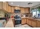 Well-lit kitchen with wood cabinets, stainless steel appliances, and tile backsplash at 4556 Kenilworth Ct, Las Vegas, NV 89147