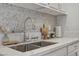 Modern kitchen sink area features stainless steel fixtures, quartz countertops, and a mosaic tile backsplash at 5171 Lindell Rd # 201, Las Vegas, NV 89118