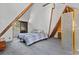 Carpeted bedroom with exposed beams, neutral color scheme and access to a private outdoor balcony at 5230 Whispering Robin Ln, Mount Charleston, NV 89124
