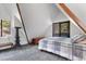 Bright bedroom with sloped ceilings, a window, and a sliding glass door to a balcony at 5230 Whispering Robin Ln, Mount Charleston, NV 89124