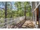 A spacious deck surrounded by trees features a white railing, creating a peaceful outdoor space at 5230 Whispering Robin Ln, Mount Charleston, NV 89124