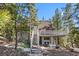 Multi-level A-frame home with a staircase, balcony, and outdoor seating area nestled among tall trees at 5230 Whispering Robin Ln, Mount Charleston, NV 89124