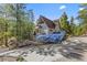 Exterior of the home featuring a driveway, pine trees, and solar panels at 5230 Whispering Robin Ln, Mount Charleston, NV 89124