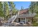Two-story gray A-frame home with large porch and outdoor dining space at 5230 Whispering Robin Ln, Mount Charleston, NV 89124