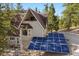 A-frame home with solar panels and a bay window, set amidst tall pine trees at 5230 Whispering Robin Ln, Mount Charleston, NV 89124
