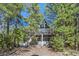 A-frame home with a large window and balcony nestled among tall trees at 5230 Whispering Robin Ln, Mount Charleston, NV 89124