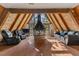 Inviting A-frame living room with wood paneling, large fireplace, and views of the surrounding forest at 5230 Whispering Robin Ln, Mount Charleston, NV 89124
