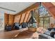 Cozy A-frame living room featuring wood paneling, modern fireplace, and comfortable seating area with scenic views at 5230 Whispering Robin Ln, Mount Charleston, NV 89124