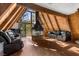 Open A-frame living room featuring wood paneling, modern fireplace, and comfortable seating with forest views at 5230 Whispering Robin Ln, Mount Charleston, NV 89124