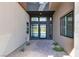 Contemporary home entrance featuring a glass door, stone walkway, and desert landscaping at 5364 Succulent Rose Dr, Las Vegas, NV 89135