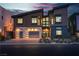 Modern home exterior showcasing garage doors with horizontal windows and dramatic evening lighting at 5364 Succulent Rose Dr, Las Vegas, NV 89135