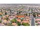 This aerial view shows a neighborhood featuring mature trees, uniform tile roofs, and street signage at 5639 Guiding Star Cir, North Las Vegas, NV 89031