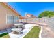 A backyard featuring manicured grass, a stone table, and a covered patio at 5639 Guiding Star Cir, North Las Vegas, NV 89031