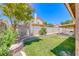 A backyard with mature landscaping, a stone wall, and a covered patio at 5639 Guiding Star Cir, North Las Vegas, NV 89031