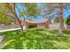 Charming one-story home featuring mature trees and lush green lawn at 5639 Guiding Star Cir, North Las Vegas, NV 89031