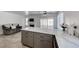 Open kitchen with quartz countertops, stainless appliances, gray cabinets, and adjacent living room with fireplace at 5639 Guiding Star Cir, North Las Vegas, NV 89031