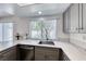 Close-up view of a modern kitchen featuring quartz countertops, stainless steel sink and grey cabinets at 5639 Guiding Star Cir, North Las Vegas, NV 89031