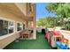 Backyard features artificial grass, covered patio with a dining set, grill, and play area at 67 Dow Jones St # 2, Henderson, NV 89074