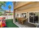 Backyard with artificial grass and covered patio featuring a dining set and play area at 67 Dow Jones St # 2, Henderson, NV 89074