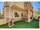 Backyard with artificial grass, a dining table set, and access to an upper balcony at 67 Dow Jones St # 2, Henderson, NV 89074