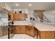 Corner view of kitchen showcases stainless steel appliances, wood cabinetry, and white countertops open to stairs at 67 Dow Jones St # 2, Henderson, NV 89074