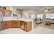 Open kitchen with wood cabinets, stainless steel appliances, and white countertops looks into the living room at 67 Dow Jones St # 2, Henderson, NV 89074