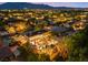 Nighttime aerial view of a neighborhood showcasing a property with a pool and lush landscaping at 7001 Via Locanda Ave, Las Vegas, NV 89131
