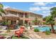 Expansive backyard featuring a pool, tiki bar, lush landscaping, and multiple seating areas at 7001 Via Locanda Ave, Las Vegas, NV 89131