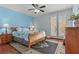 Bedroom with blue walls, ceiling fan, a bed, and French doors with light shining through at 7001 Via Locanda Ave, Las Vegas, NV 89131