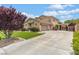 Attractive home featuring a well-manicured lawn, a three-car garage, and a spacious driveway at 7001 Via Locanda Ave, Las Vegas, NV 89131
