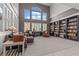 Grand living room featuring soaring ceilings, large windows, and custom bookshelves at 7001 Via Locanda Ave, Las Vegas, NV 89131
