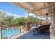 Relaxing covered patio overlooking a sparkling pool and lush tropical landscaping at 7001 Via Locanda Ave, Las Vegas, NV 89131