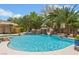 Luxurious backyard pool with a rock waterfall, lush landscaping, and a slide at 7001 Via Locanda Ave, Las Vegas, NV 89131