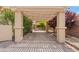 Covered walkway with lush greenery, string lights and stone pavers leading to a private backyard space at 7001 Via Locanda Ave, Las Vegas, NV 89131