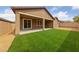 Backyard featuring artificial grass, gravel, and a covered patio at 705 Coastal Lagoon St, Henderson, NV 89002