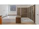 Modern bathroom featuring a tub, shower, and granite-style accents at 705 Coastal Lagoon St, Henderson, NV 89002