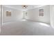 Spacious bedroom with plush carpeting, ceiling fan, and multiple windows at 705 Coastal Lagoon St, Henderson, NV 89002
