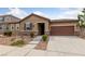 Charming single-story home featuring a stone veneer, desert landscaping, and a two-car garage at 705 Coastal Lagoon St, Henderson, NV 89002